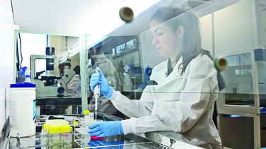 A bioengineering student working under a fume hood