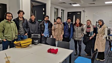 A group of people standing in a classroom