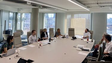 all staff at the workshop gathered around the conference table discussing topics in relation to the workshop