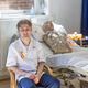 Harry, a male student nurse, sits in front of a hospital bed with an NG tube manikin.
