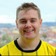 Student Jack Roberts smiling at the camera with a blurred city backdrop